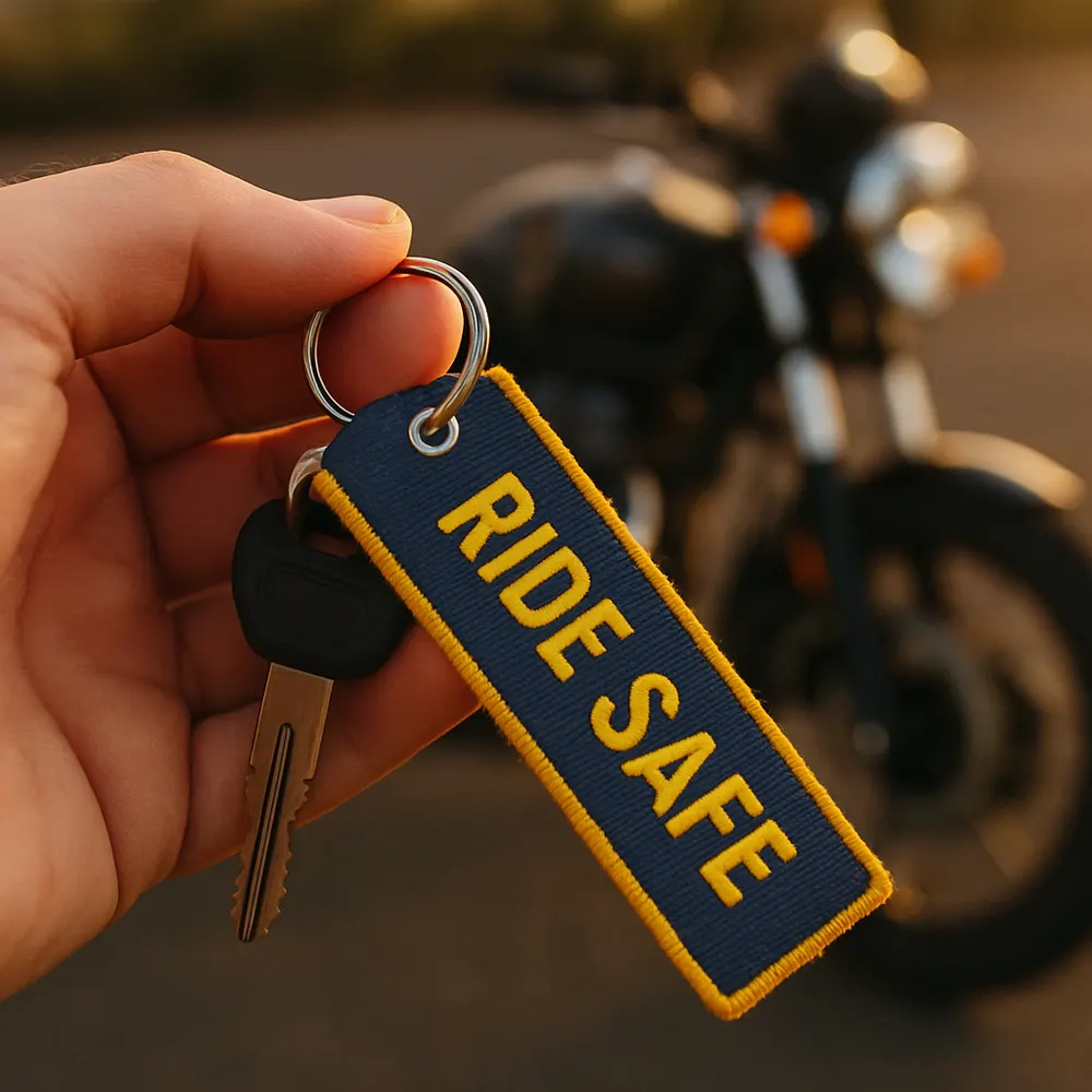 Custom embroidered MyMotoTag motorcycle key tag held in a rider's hand
